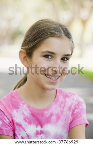 Portrait of Smiling Tween Girl with Braces  Wearing Tye-dyed T-Shirt