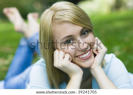 Pretty Teenage Girl Lying on Blanket in a Park