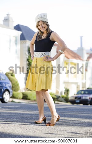 Pretty Young Woman in a Bright Yellow Skirt Posing in The Street