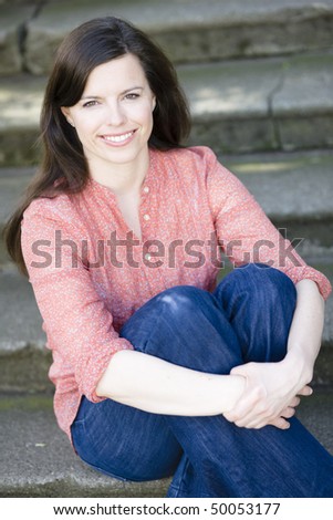 Pretty Young Woman Sitting Outside on Steps With Legs Crossed