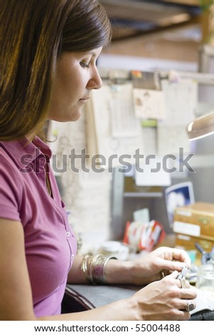 Profile of a Young Woman Jeweller Holding Pliers Making a Piece of Jewelry