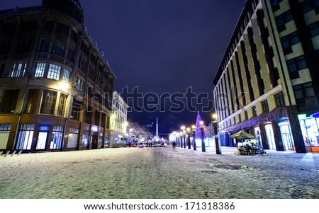 Central crossroad in Old Riga, Latvia at winter night with Monument of Freedom on a background