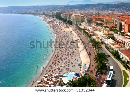 Luxury resort of French riviera. Beautiful panorama city of Nice in France. Sunny, summer day. Mediterranean sea, public beach, famous quay, palms and houses of Nice.