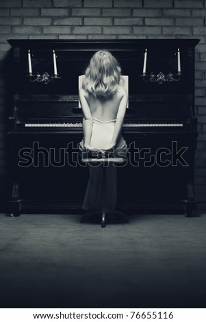 beautiful young woman playing the piano (black and white photo)