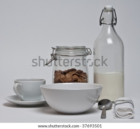 set of plates , corn flakes in jar , stylish bottle of milk