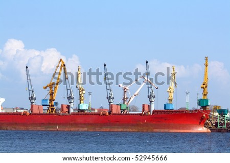 Red ship and port cranes