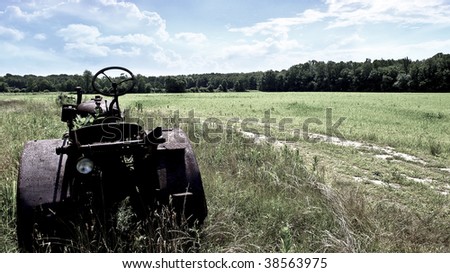 Rusty Antique Tractor on green field