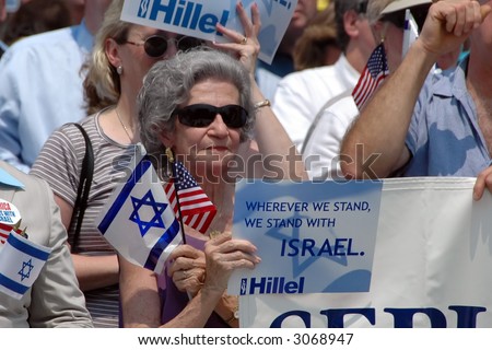 Older woman holding flag and sign at pro-Israel rally in Washington, DC