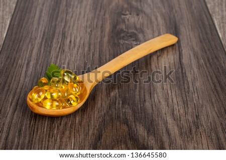 spoon full of tablets on wooden table