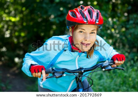 Happy Young woman leaned over the handlebars of her bike.