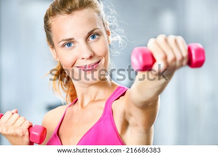 Young woman with dumbbells in her hands.