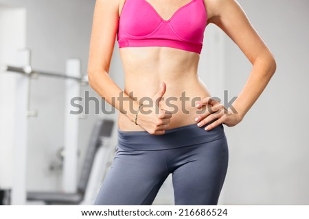 Closeup of young slim woman with six-pack torso.