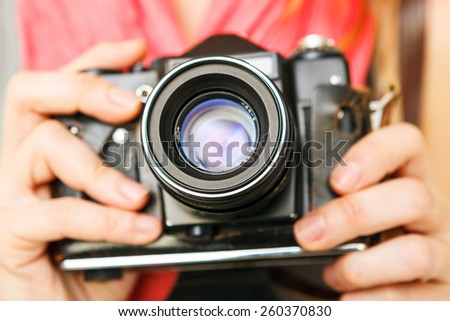 Woman photographer holding old 35mm film camera.