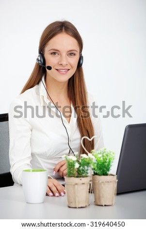 Portrait of happy cheerful beautiful young support phone operator with headset.