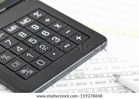 Calculator with pen on paper sheets with numbers - finance expenses or budget concept