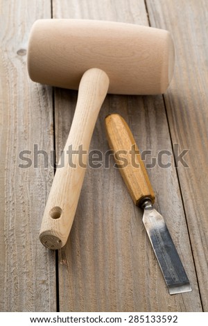 Wooden mallet and chisel on wooden workbench table