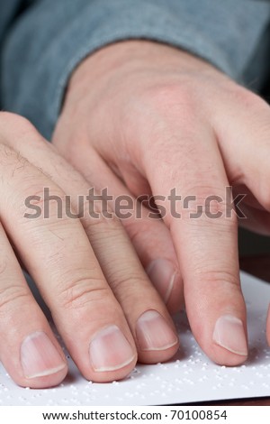 Close up of male hands reading braille text