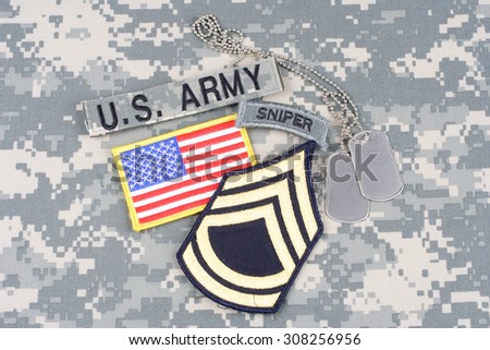 KIEV, UKRAINE - August 21, 2015. US ARMY Sergeant First Class rank patch, sniper tab, flag patch,  with dog tag on camouflage uniform