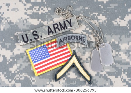 KIEV, UKRAINE - August 21, 2015. US ARMY Private rank patch, airborne tab, flag patch,  with dog tag on camouflage uniform
