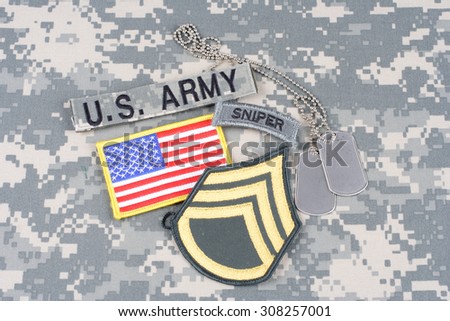 KIEV, UKRAINE - August 21, 2015. US ARMY Staff Sergeant rank patch, sniper tab, flag patch,  with dog tag on camouflage uniform