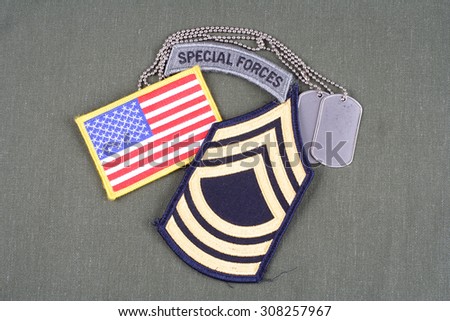 KIEV, UKRAINE - August 21, 2015.  US ARMY Master Sergeant rank patch, special forces tab, flag patch and dog tag on olive green uniform