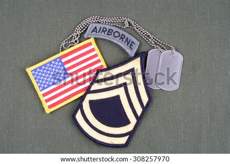 KIEV, UKRAINE - August 21, 2015.  US ARMY Sergeant First Class rank patch, airborne tab, flag patch and dog tag on olive green uniform