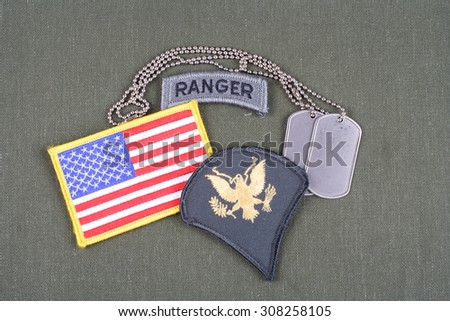 KIEV, UKRAINE - August 21, 2015.  US ARMY Specialist rank patch, ranger tab, flag patch and dog tag on olive green uniform