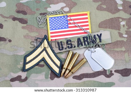 KIEV, UKRAINE - September 5, 2015. US ARMY Corporal rank patch, flag patch, with dog tag with 5.56 mm rounds on camouflage uniform