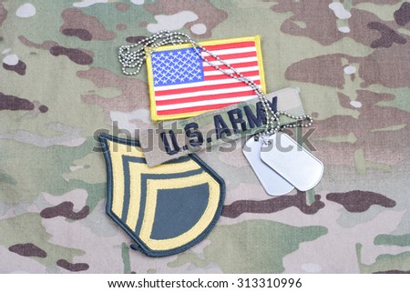 KIEV, UKRAINE - September 5, 2015. US ARMY Staff Sergeant rank patch,  flag patch, with dog tag on camouflage uniform