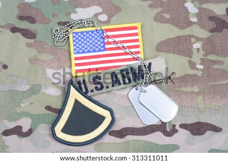 KIEV, UKRAINE - September 5, 2015. US ARMY Private First Class rank patch,  flag patch, with dog tag on camouflage uniform