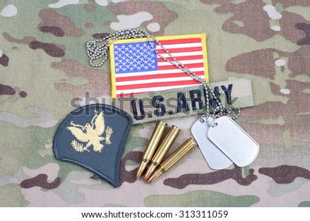 KIEV, UKRAINE - September 5, 2015. US ARMY Specialist rank patch, flag patch, with dog tag with 5.56 mm rounds on camouflage uniform