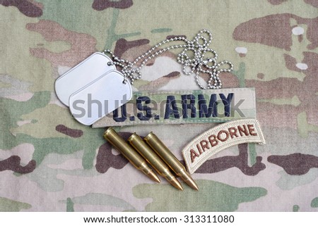KIEV, UKRAINE - September 5, 2015. US ARMY airborne tab, flag patch,  with dog tag and 5.56 mm rounds on camouflage uniform