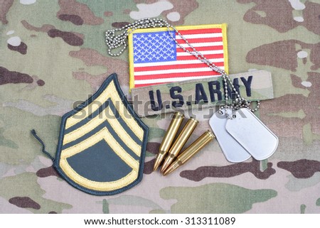 KIEV, UKRAINE - September 5, 2015. US ARMY Staff Sergeant rank patch,  flag patch, with dog tag with 5.56 mm rounds on camouflage uniform