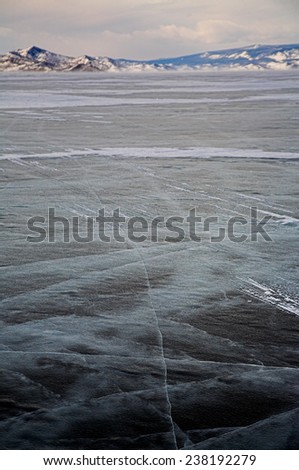Winter baikal. Ice field and mountain on background