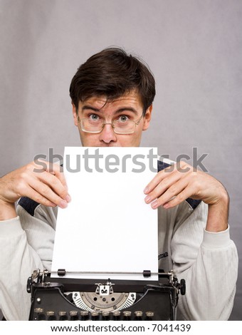 man with vintage typewriter and white paper sheet