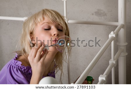 young beauty girl make soap bubble in the room