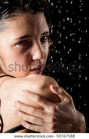Young girl in rain isolated on black background