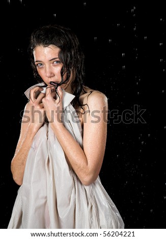 Young girl with shirt in rain isolated on black background