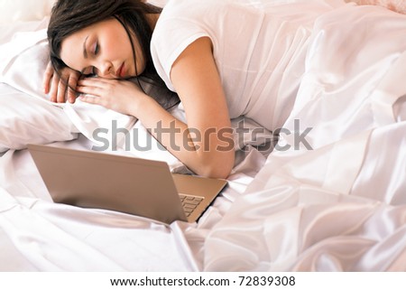beauty girl with laptop lying in the bed