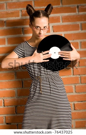 woman with vinyl plate on brick wall background