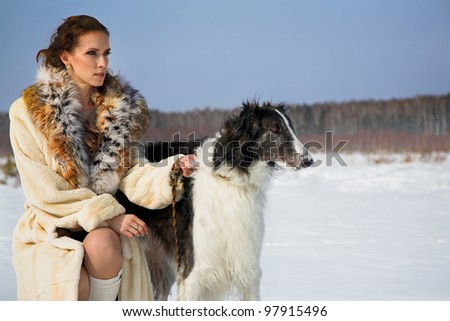beauty woman with dog in the winter country
