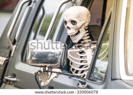 scary human skeleton figure driving a truck
