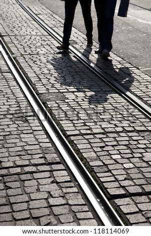 Man and Woman Cross Tram Track in Geneva, Switzerland, Europe