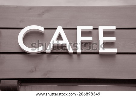 White Cafe Sign on Wooden Panel Background in Black and White Sepia Tone