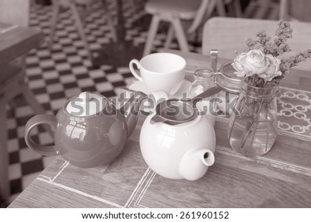 Tea Pots, with Cup and Saucer on Cafe Table in Black and White Sepia Tone