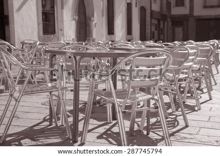 Cafe Tables and Chairs in Outdoor Setting in Black and White Sepia Tone