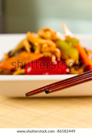 Chinese specialty blurred with chopsticks in focus
