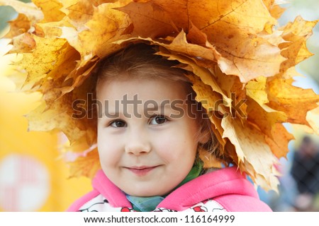 Child happy face with yellow maples wreath