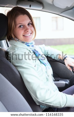 Happy woman inside of car on driver seat