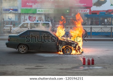 SAINT-PETERSBURG, RUSSIA-NOVEMBER 11: Burning car is on city street with used extinguishers on November 11, 2012 in Saint-Petersburg, Russia. Self-ignition car wiring. No one was injured.